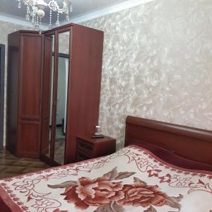 a bedroom with a bed with a flower patterned wall at Сдаётся в 2-х ком.кв. 1 комната на берегу моря на 2 человека. Проживание с хозяевами. in Pizunda