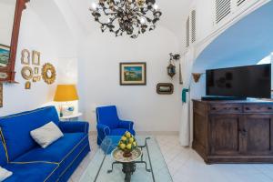a living room with a blue couch and a tv at CasaMia Positano - sea view and private outdoor hot tub in Positano