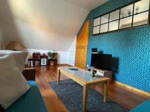 a living room with a couch and a table at Gîte Pressoir Armand in Saint-Gâtien-des-Bois