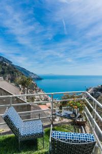 a view of the ocean from a balcony with two chairs at CasaMia Positano - sea view and private outdoor hot tub in Positano