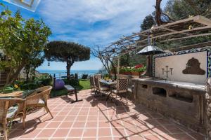 a patio with a table and chairs and a fireplace at CasaMia Positano - sea view and private outdoor hot tub in Positano