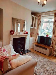 a living room with a fireplace and a television at Boutique Cottage In The Heart Of Buxton Town in Buxton