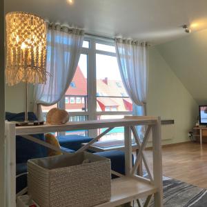 a dining room with a table and a large window at Apartamentai Taikos 24 in Nida