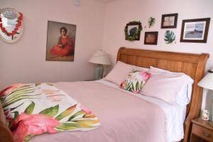 a bedroom with a bed with a pink comforter at Seabank House Bed and Breakfast Aloha in Pictou