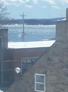 a window on a building with a view of the water at Seabank House Bed and Breakfast Aloha in Pictou