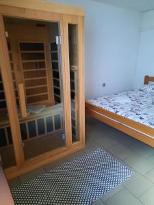 a room with a bed and a glassoir with a glass door at APARTMA BENY with SAUNA in Žaga