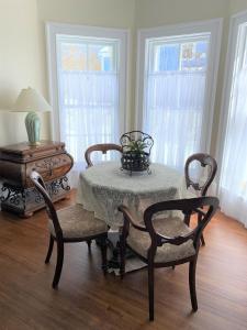 een eetkamer met een tafel en twee stoelen en een tafel met een tafel bij Seabank House Bed and Breakfast Aloha in Pictou