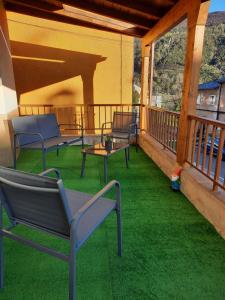 a patio with chairs and a table on a balcony at A casa Daló in Folgoso