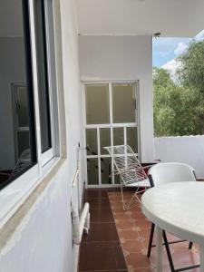 d'un balcon avec une table, des chaises et une fenêtre. dans l'établissement Sol y Luna Teotihuacan, à San Sebastian Xolalpa