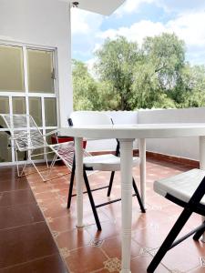 a white table and chairs sitting on a porch at Sol y Luna Teotihuacan in San Sebastian Xolalpa