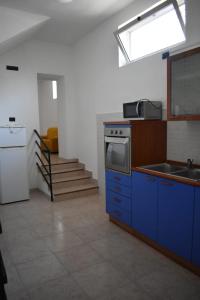 cocina con armarios azules, fregadero y ventana en A casa di Gió e Chri, en Minturno