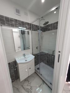 a bathroom with a shower and a sink and a glass shower backdoor at GioRi in Giardini Naxos