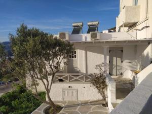 a white house with a tree in front of it at Ios Village View in Ios Chora