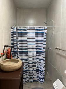 a bathroom with a shower with a toilet and a shower curtain at Sol y Luna Teotihuacan in San Sebastian Xolalpa