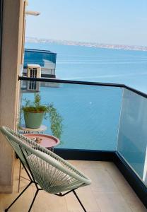 a chair on a balcony with a view of the water at Luxury Mamaia Central in Mamaia
