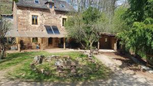 una antigua casa de piedra con un jardín delante de ella en maison isolée dans les vignes et les bois en Valady