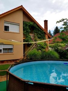 a swimming pool in front of a house at Borostyán Apartmann in Balatonföldvár