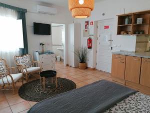 a room with a kitchen with a table and chairs at Apartamento Estúdio Pinhalmar in Vila Nova de Milfontes