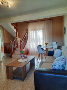 Aktaia Villa في إيريسوس: غرفة معيشة مع أريكة وطاولة