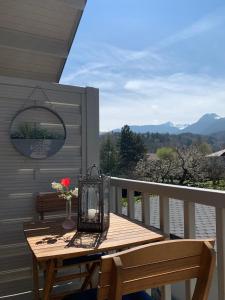 a wooden table with a vase of flowers on a balcony at Hygge Lodge Annecy in Doussard