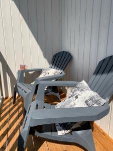 two blue chairs sitting on a wooden deck with at Hygge Lodge Annecy in Doussard