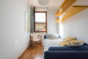 salon z niebieską kanapą i oknem w obiekcie La Musa di via Dante we Florencji