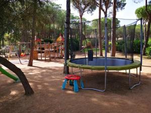 a playground with a trampoline in a park at Calaverde Pula Il Giardino di Alessandra in Fort Village