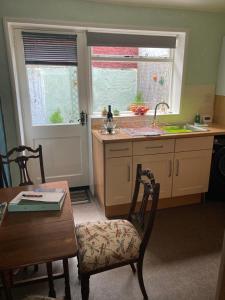 a kitchen with a sink and a table with a chair at Bedford House Retreat in Scarborough