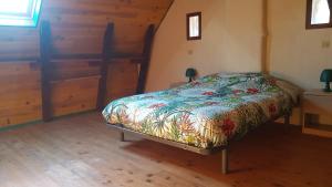 ein Schlafzimmer mit einem Bett in einem Zimmer mit Holzböden in der Unterkunft maison isolée dans les vignes et les bois in Valady