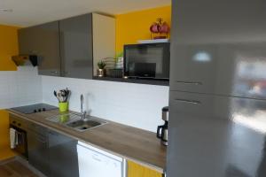 a kitchen with a stainless steel refrigerator and a sink at Mini villa T3 climatisée, vue mer, cosy & moderne in Olmeto