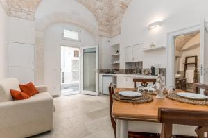 a kitchen and living room with a table and a couch at La Casetta di Chloè in Ostuni