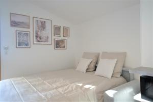 ein weißes Sofa in einem Zimmer mit Bildern an der Wand in der Unterkunft STUDIO dernier étage avec terrasse - vue montagne in Cruseilles