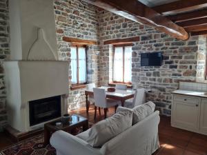 a living room with a couch and a table and a fireplace at Amanita in Tsagarada