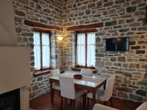 comedor con pared de ladrillo, mesa y sillas en Amanita, en Tsagkarada