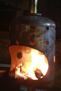 um fogo está queimando em um fogão de metal em Camellón de la Ferrería em Pacho
