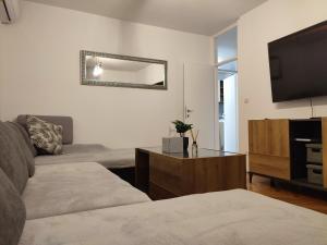 a living room with a couch and a flat screen tv at Apartman Ivan in Kaštela
