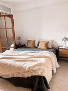 um quarto com uma cama grande com almofadas em Casa Moreno em Belén de Escobar