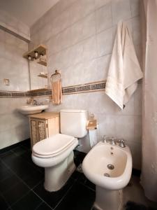 a bathroom with a white toilet and a sink at Casa Moreno in Belén de Escobar