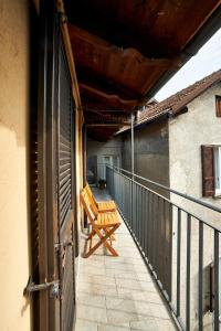 - un balcon avec un banc en bois sur le côté du bâtiment dans l'établissement Bella Omegna Apartments, à Omegna