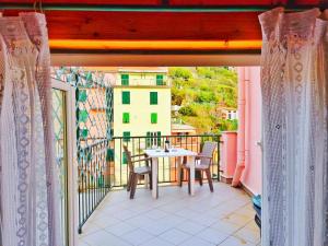 a patio with a table and chairs on a balcony at Good vibes penthouse Ca Lidia 5Terreholiday in Riomaggiore