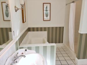 a white bath tub sitting next to a white sink at Hearthside Inn in Bar Harbor
