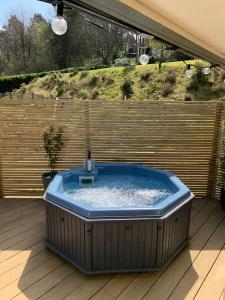 Un grand bain à remous est installé sur une terrasse en bois. dans l'établissement Beauslodge Authentic Log Cabin With Private Hot Tub, à Arford