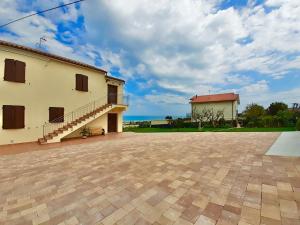 ein Haus mit einer Terrasse und einem Gebäude mit einem Himmel in der Unterkunft Casa Vacanze con Vista Mare e Giardino - Amanecer in Marzocca di Senigallia