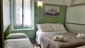 een groene kamer met een bed met handdoeken erop bij Casa Ninnì Sanremo in Sanremo