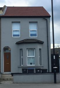 een wit huis met twee ramen en een bruine deur bij Dunamis Staycation 5 in Croydon +19 foto's