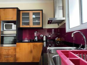 a kitchen with a sink and a microwave at Brazão Guest House in Santana