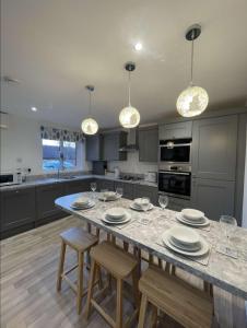 a kitchen with a large table with chairs and wine glasses at A beautiful house in a scenic town location. in Louth