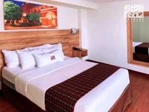 Habitación de hotel con cama grande y espejo en Terramistica Vallecito, en Arequipa