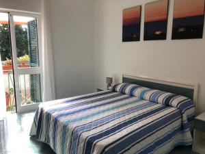 a bedroom with a bed with a striped blanket on it at Casetta Forio in Forio d'Ischia