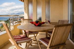 stół z krzesłami i miskę owoców na balkonie w obiekcie Montenegro Apartments Utjeha w mieście Utjeha